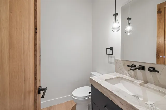 a bathroom with a granite countertop sink a toilet and a mirror