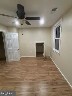 a view of a hallway with wooden floor and a refrigerator