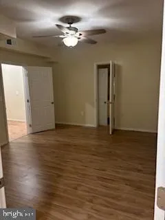 a view of an empty room with window and wooden floor