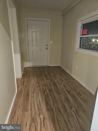 a view of a room with wooden floor and entryway