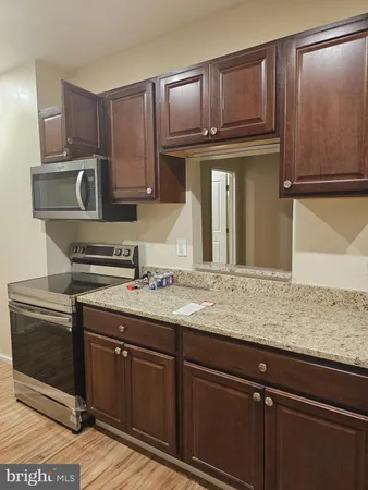 a kitchen with granite countertop wood cabinets and stainless steel appliances