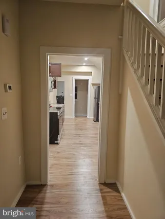 a view of a hallway with wooden floor and staircase