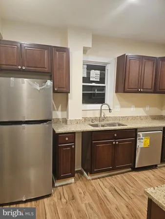 a kitchen with granite countertop a refrigerator and a sink