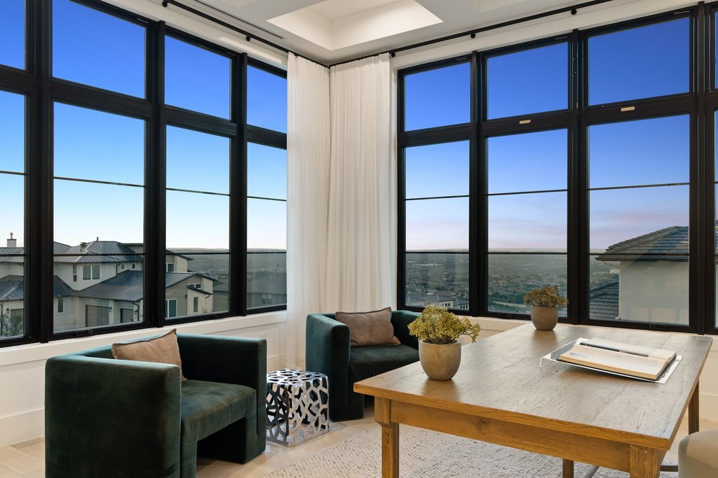 7117 Davenport Divide Road Austin, TX 78738 - Photo 12 of 40 Vast window walls frame a captivating cityscape, providing a dynamic backdrop for comfortable living.
