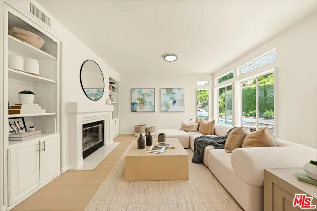 a living room with furniture large window and wooden floor