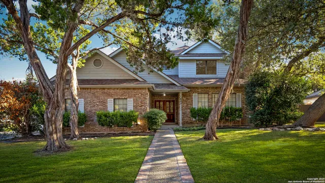 a front view of a house with a yard and potted plants
