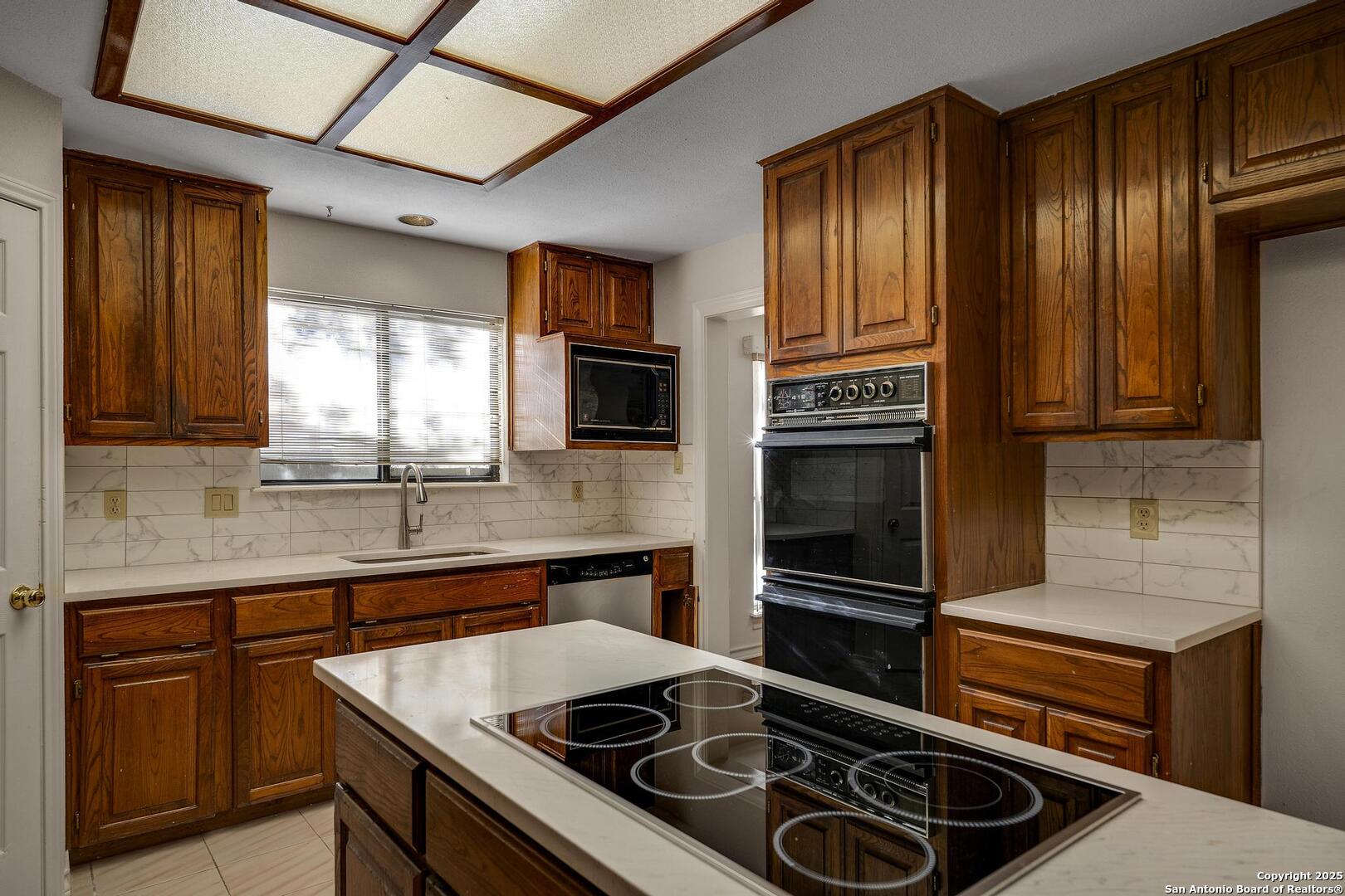 1603 Hawks Ridge Street San Antonio, TX 78248 - Photo 13 of 39 a kitchen with granite countertop stainless steel appliances a stove sink and microwave