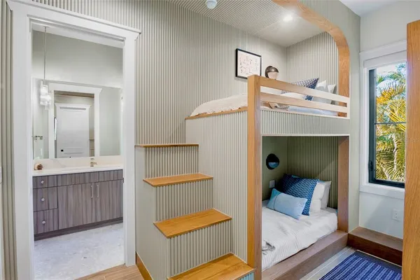 a bedroom with a bed and a flat tv screen on dresser
