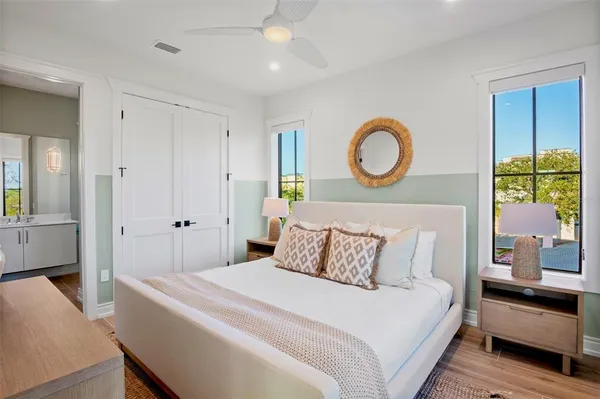 a bedroom with a large bed and a chandelier