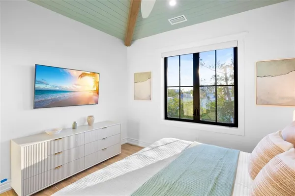 a bedroom with a bed and a large window