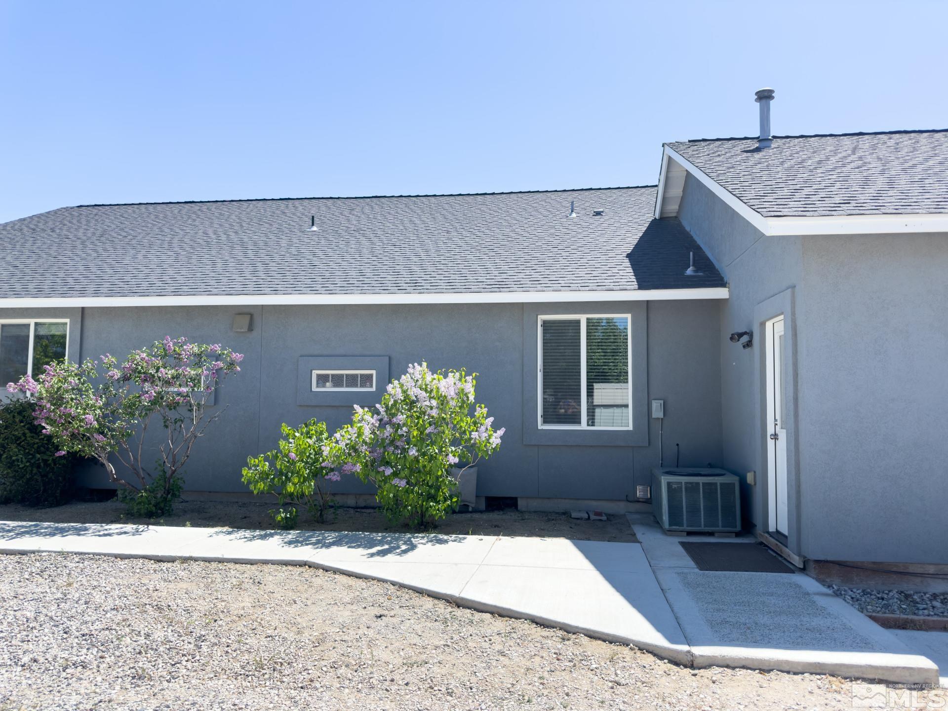 1880 Sky Ridge Drive Fallon, NV 89406 - Photo 31 of 40 a front view of a house with lots of flower plants