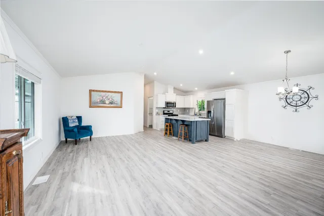 a view of a kitchen with a stove wooden cabinets and a living room