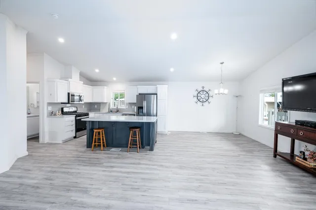 a view of kitchen with wooden floor and electronic appliances