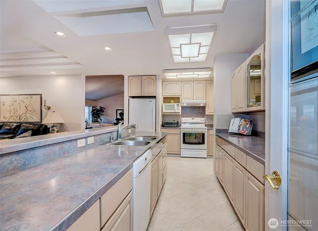 a large kitchen with granite countertop a large counter top stainless steel appliances and cabinets