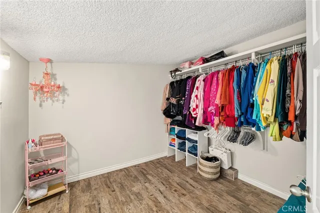 a view of walk in closet with clothes and shoes