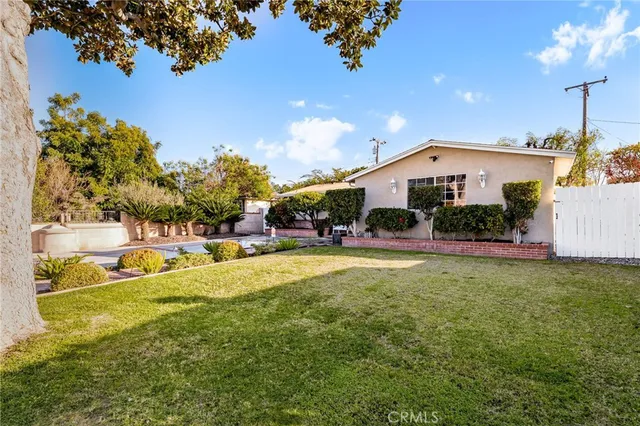 a view of a house with a big yard and large trees