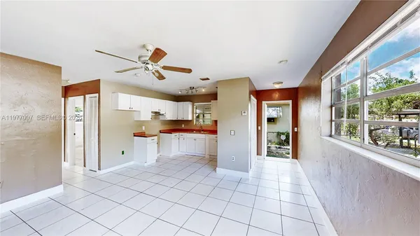 a open kitchen with stainless steel appliances kitchen island granite countertop a refrigerator and a sink