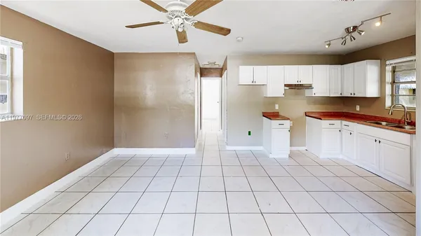 a kitchen with stainless steel appliances a white cabinet and a window