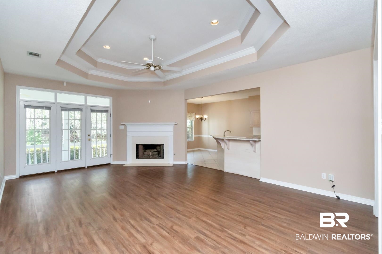 6117 Lennox Place Mobile, AL 36693 - Photo 2 of 39 Unfurnished living room with crown molding, a raised ceiling, ceiling fan, and a healthy amount of sunlight