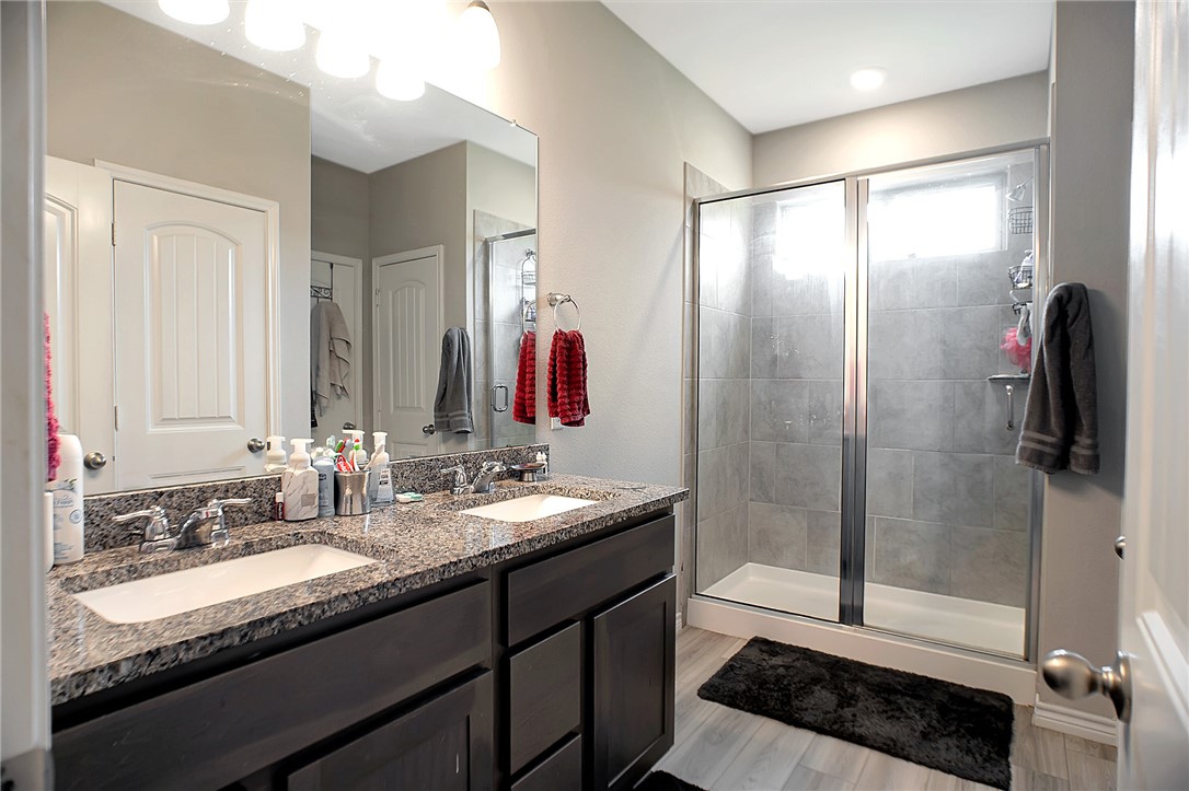2037 Rock Rdg Avenue Bryan, TX 77807 - Photo 9 of 27 a bathroom with a granite countertop sink a mirror and a shower