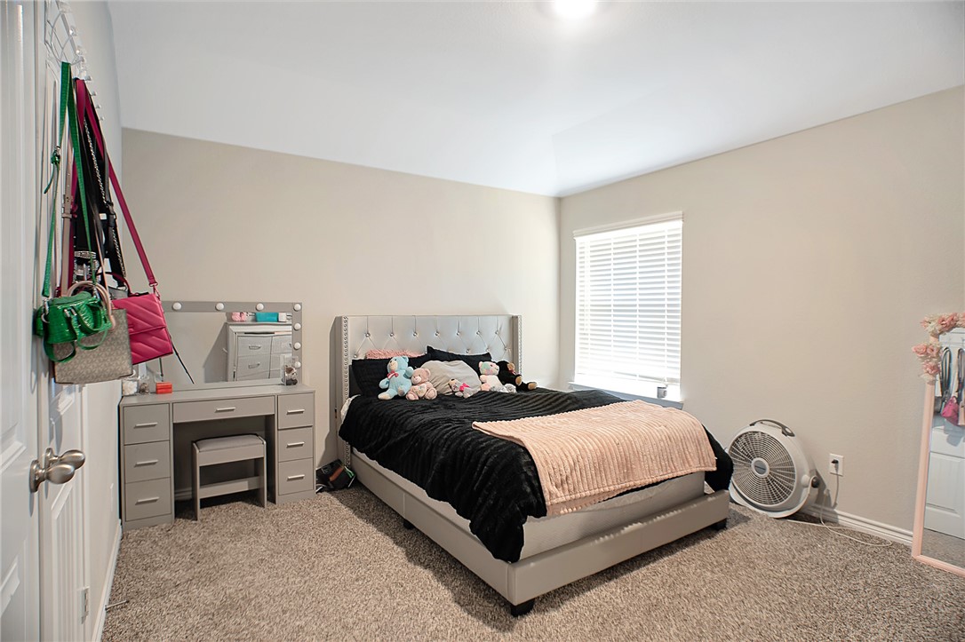 2037 Rock Rdg Avenue Bryan, TX 77807 - Photo 10 of 27 a bedroom with a bed and a flat tv screen on the dresser