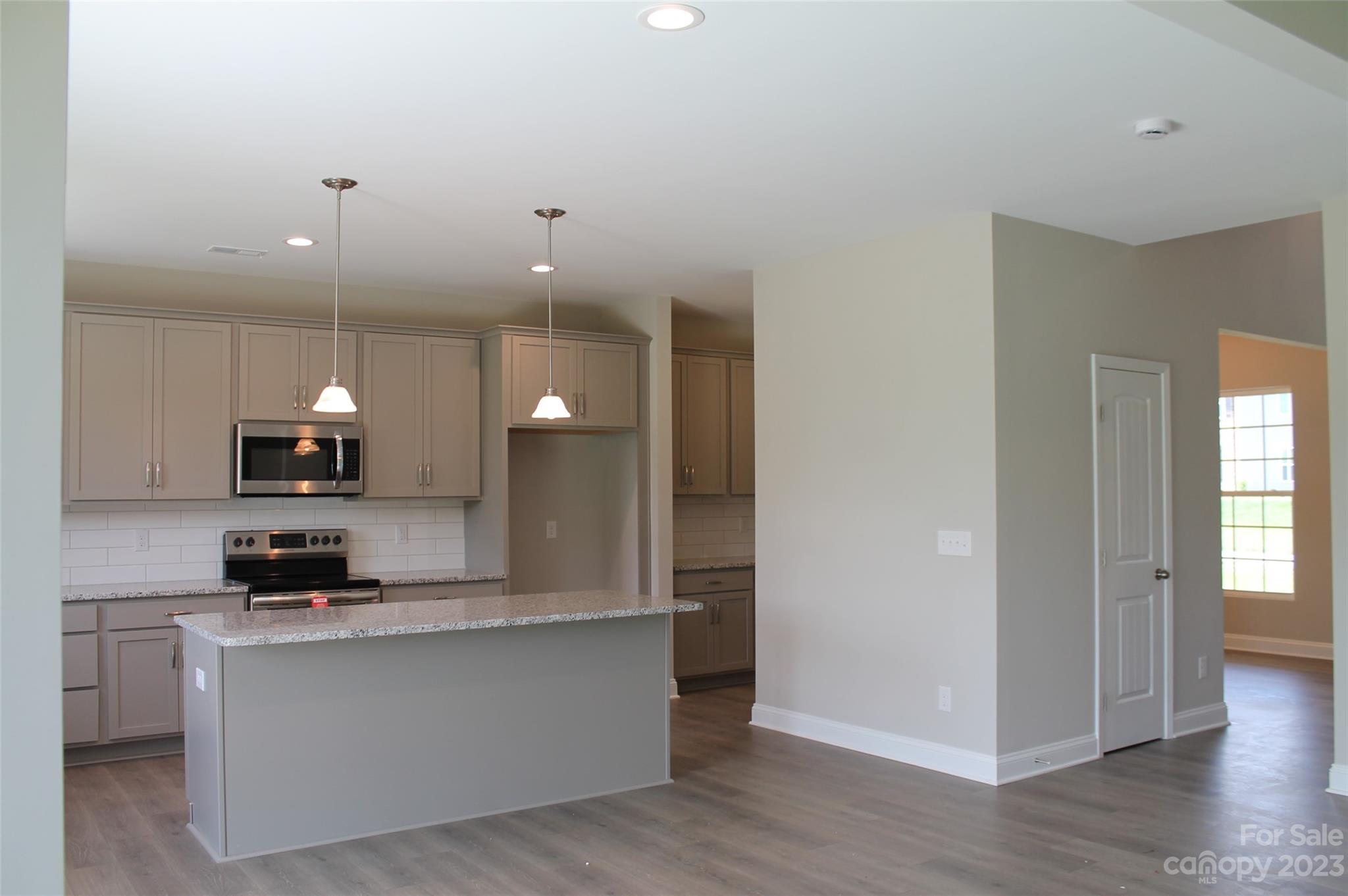 3818 New Salem Road Monroe, NC 28110 - Photo 5 of 15 a kitchen with stainless steel appliances granite countertop a sink a stove and a wooden floors