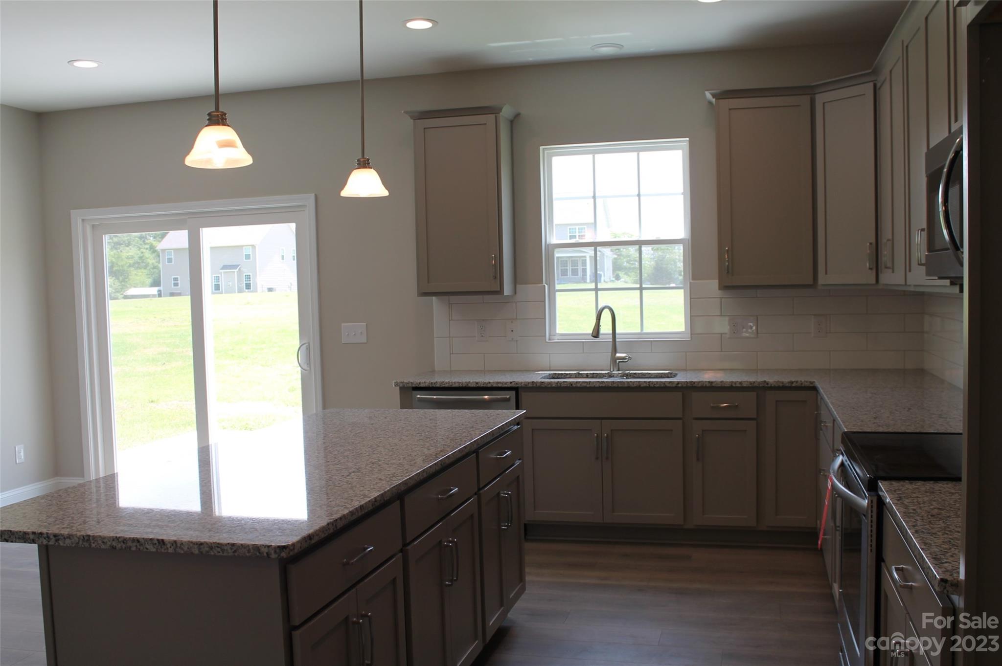3818 New Salem Road Monroe, NC 28110 - Photo 6 of 15 a kitchen with granite countertop a stove a sink a window and dining table
