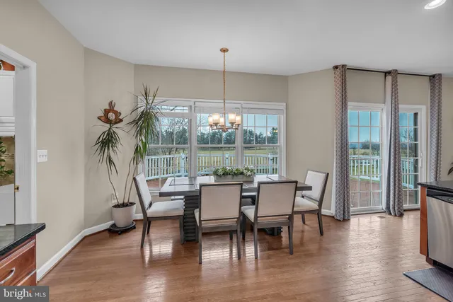 a living room with furniture kitchen view and a chandelier