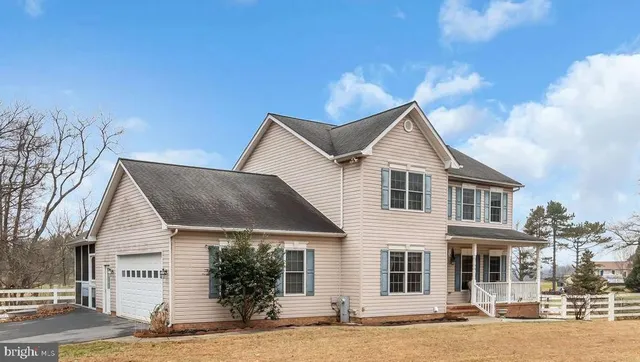 a front view of a house with yard and parking