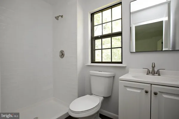 a bathroom with a toilet a sink a vanity and mirror