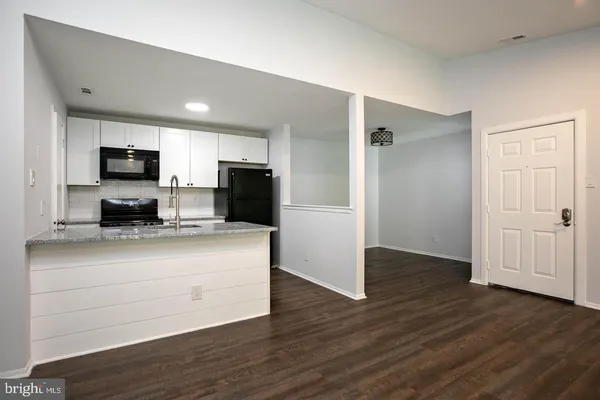 a kitchen with stainless steel appliances granite countertop a refrigerator stove top oven and sink