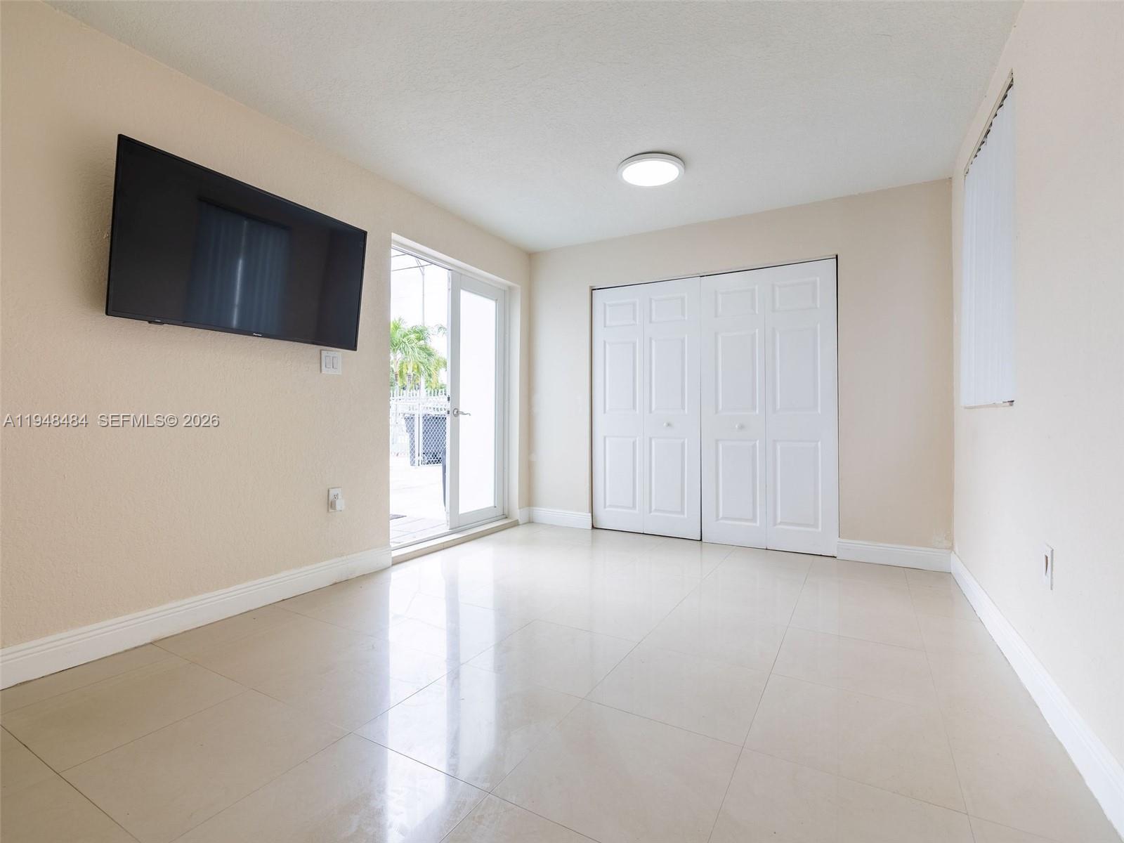 201 East 44th Street Hialeah, FL 33013 - Photo 31 of 39 a view of an empty room with wooden floor and a flat screen tv