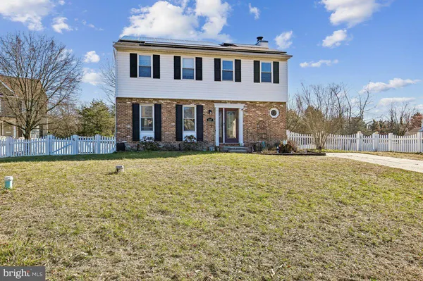 a front view of house with yard and trees in the background