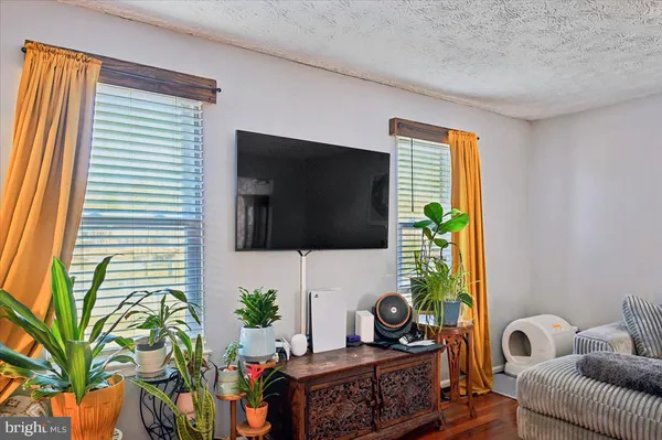 a living room with patio furniture and a flat screen tv