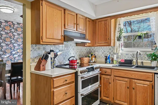 a view of a kitchen with fridge and wooden floor