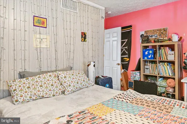a bedroom with a bed a dresser and book shelf