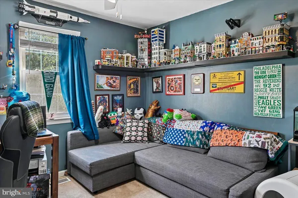 a living room with furniture a flat screen tv and a window