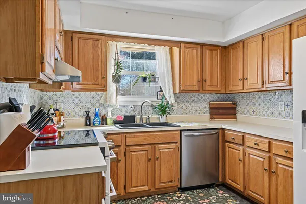 a kitchen with stainless steel appliances a sink stove and cabinets