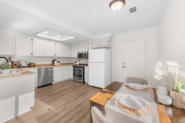 a kitchen with white cabinets and white appliances