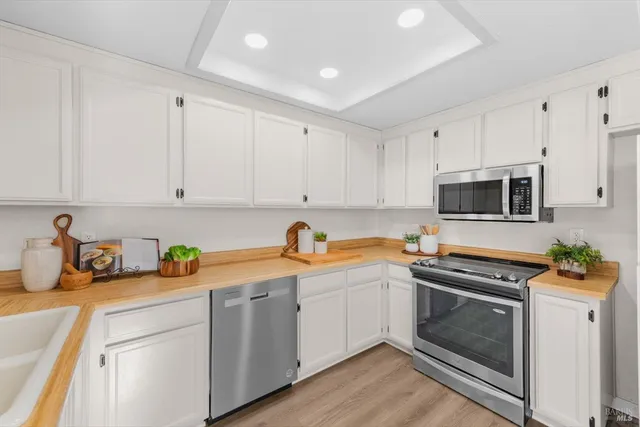 a kitchen with stainless steel appliances white cabinets and a sink