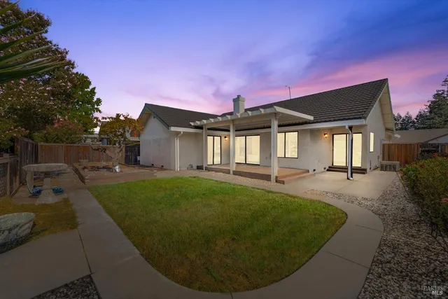 a view of a house with backyard and sitting area