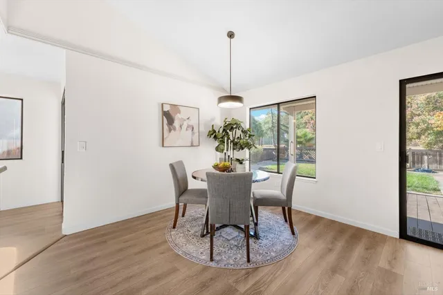 a dining room with furniture a window and wooden floor