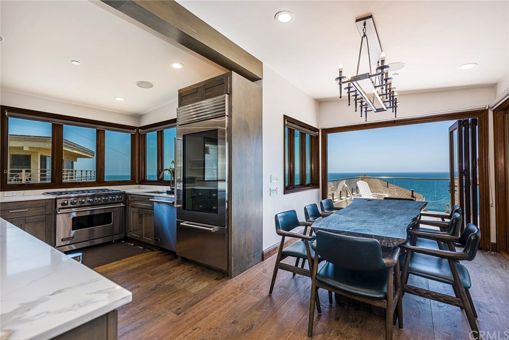 Gourmet kitchen with stainless steel Viking appliances and wine frig. Dining room with folding accordion style doors incorporate indoor and outdoor space.