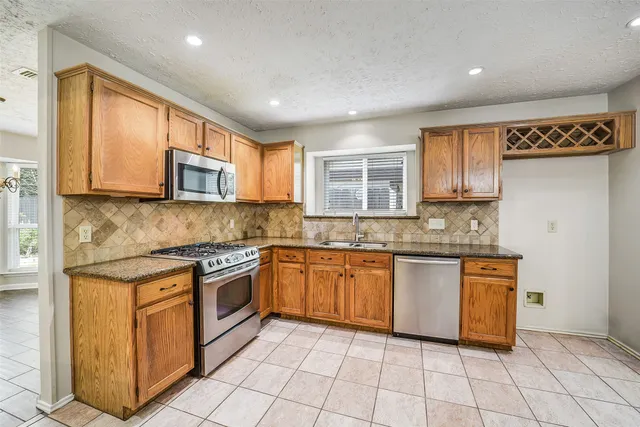 a kitchen with stainless steel appliances granite countertop a stove top oven a sink dishwasher and granite counter tops