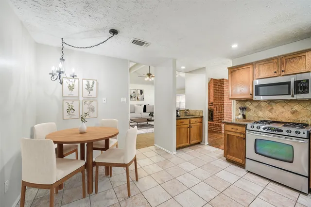 a kitchen with stainless steel appliances a stove a sink island and chairs