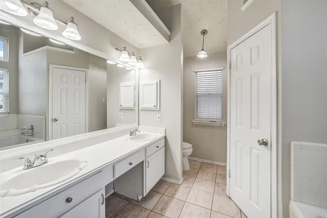 a spacious bathroom with a double vanity sink mirror and toilet