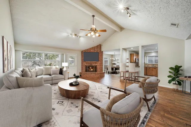 a living room with furniture a wooden floor and a chandelier
