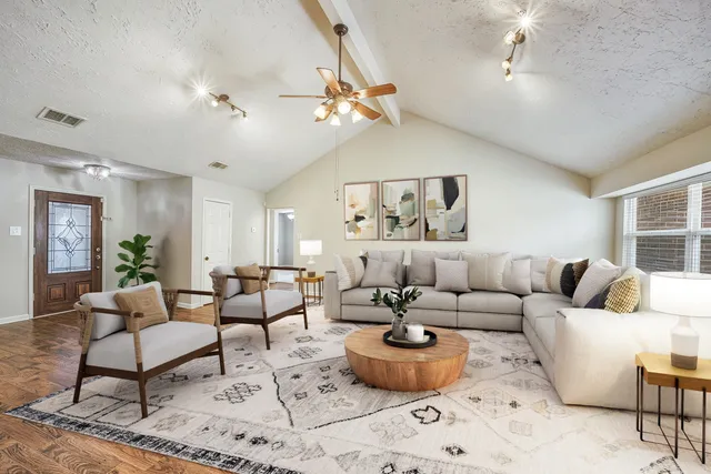 a living room with furniture a rug and a chandelier