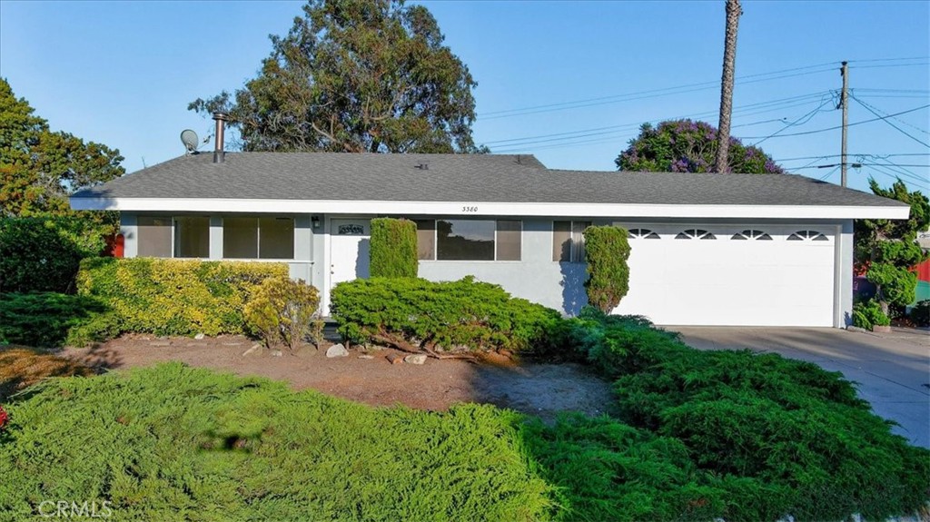 a front view of a house with a yard and potted plants