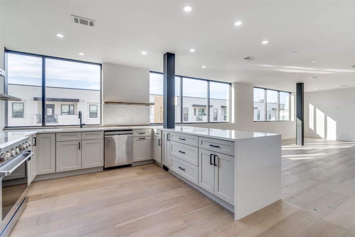 a large kitchen with stainless steel appliances double vanity and a large window